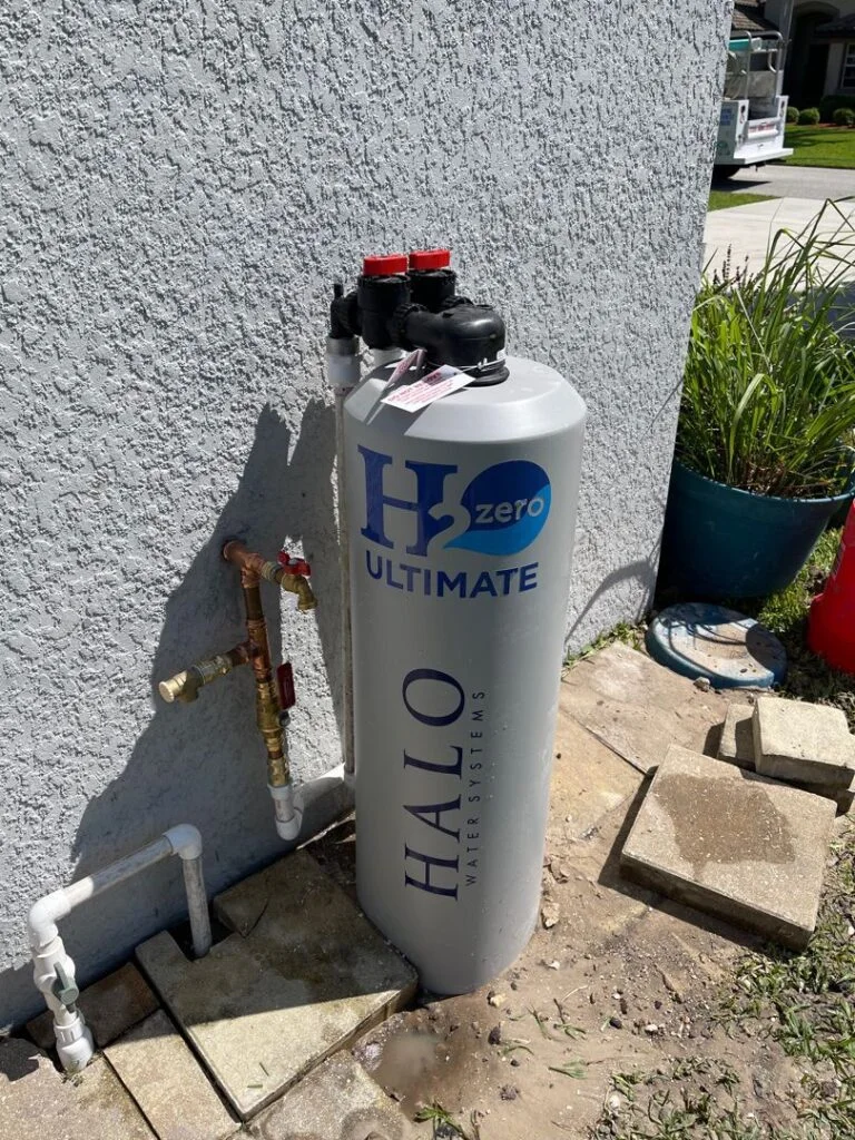 Full-height whole-home water treatment tank installed outside with copper piping