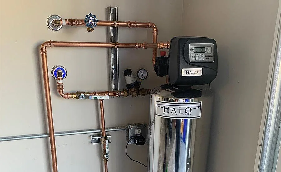 Whole-home water treatment system installed indoors with copper plumbing