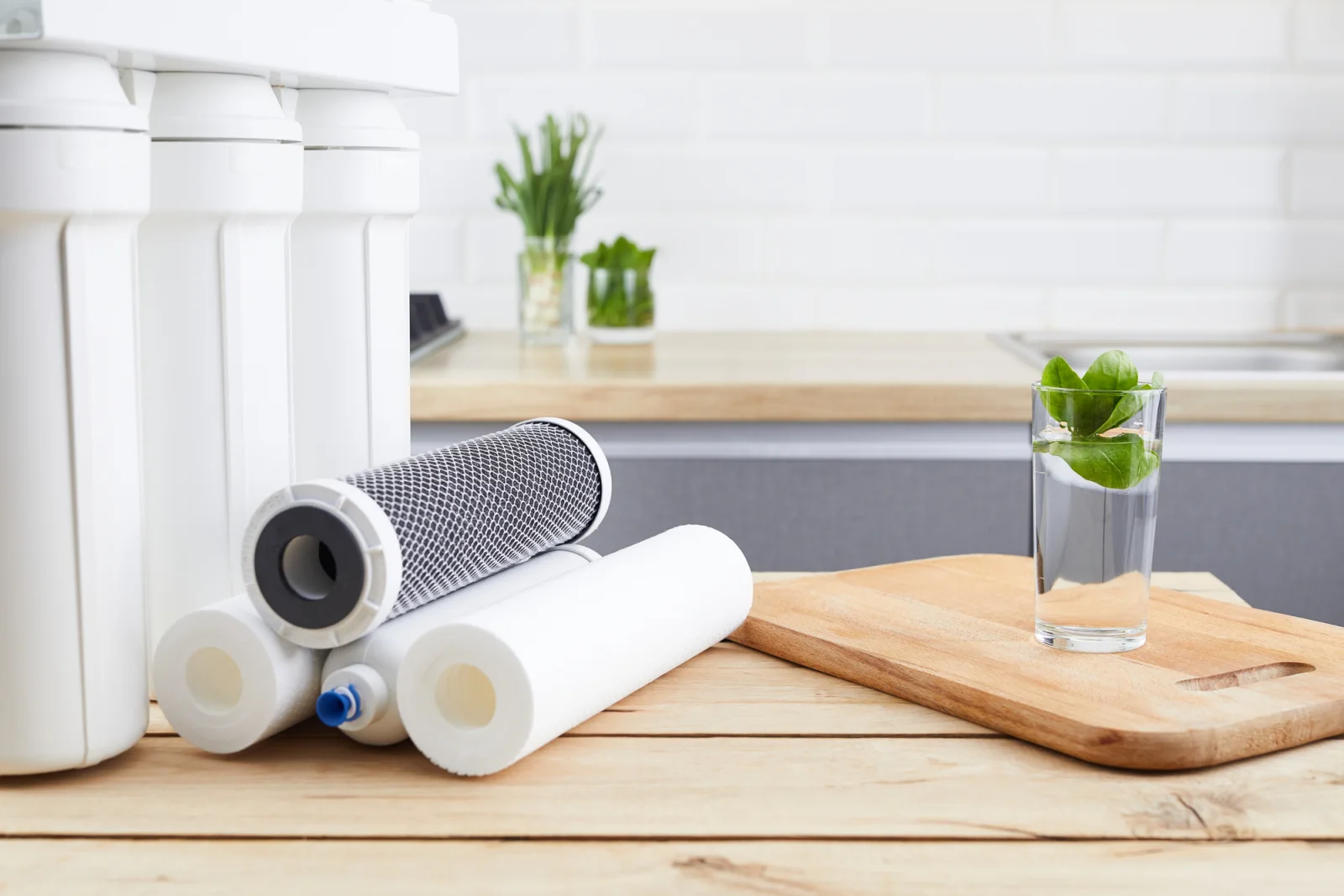 Water filtration cartridges and a glass of water in a residential kitchen